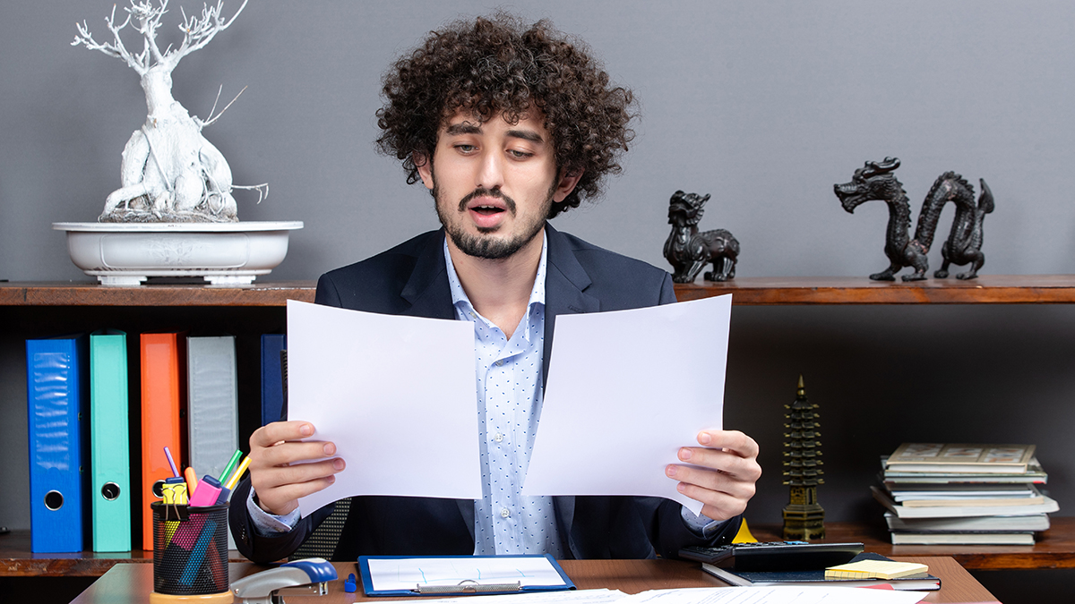 Focused and determined, the young businessman meticulously uncovers hidden bookkeeping mistakes, ensuring financial accuracy and paving the way for success.